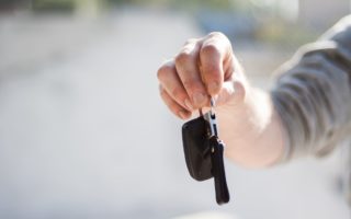Person handing over keys to a car