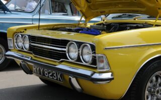 A yellow Ford Cortina with its hood up